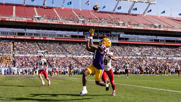 Jan 1, 2024; Tampa, FL; LSU Tigers wide receiver Chris Hilton Jr. catches a pass for a touchdown over Wisconsin Badgers safety Austin Brown during the second half at the ReliaQuest Bowl at Raymond James Stadium.